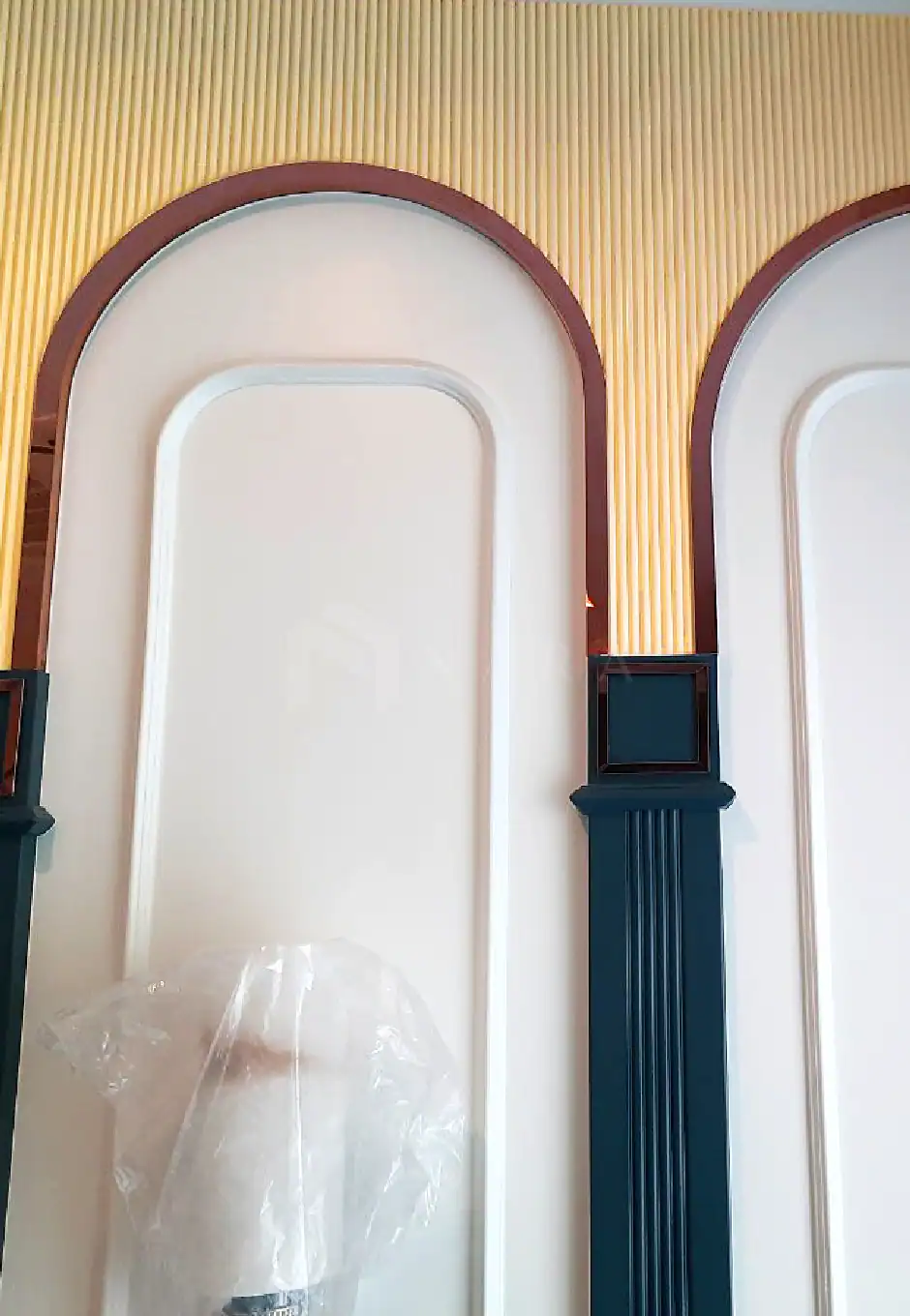 Elegant gold-colored stainless steel trim and decorative fittings enhance modern interior wall design with stylish arches and panel accents.
