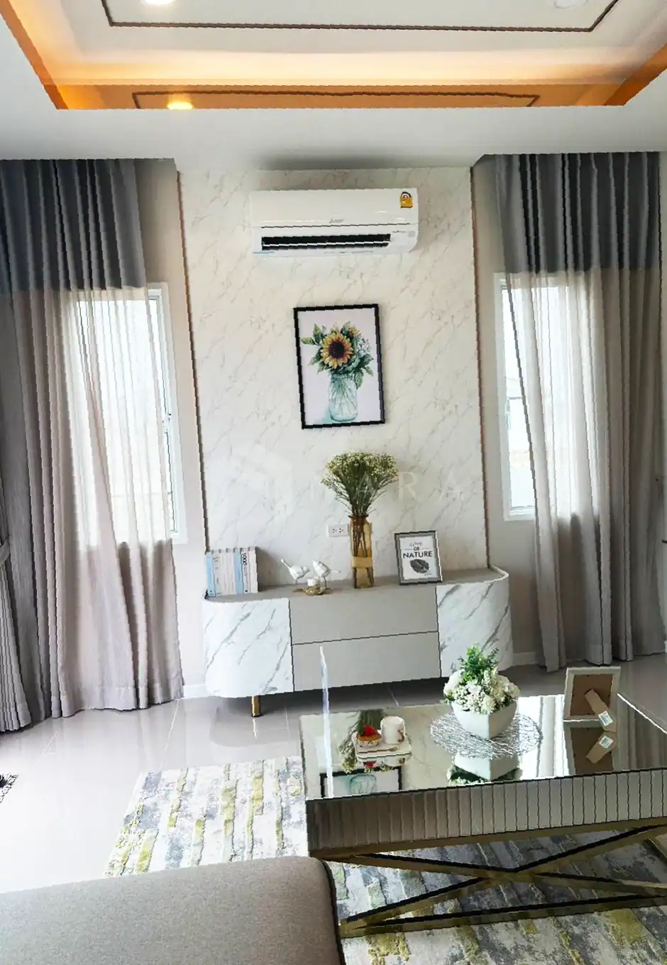 Shiny gold stainless steel trim in a modern living room, enhancing interior decor with elegant finishing touches, paired with marble-like wall panels and tasteful decorative elements.
