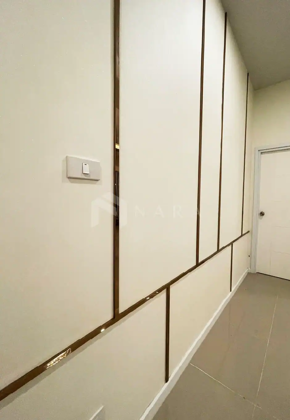 Luxurious gold-colored stainless steel trim accents on the wall, enhancing modern interior decor with a sleek, elegant finish for a contemporary aesthetic.
