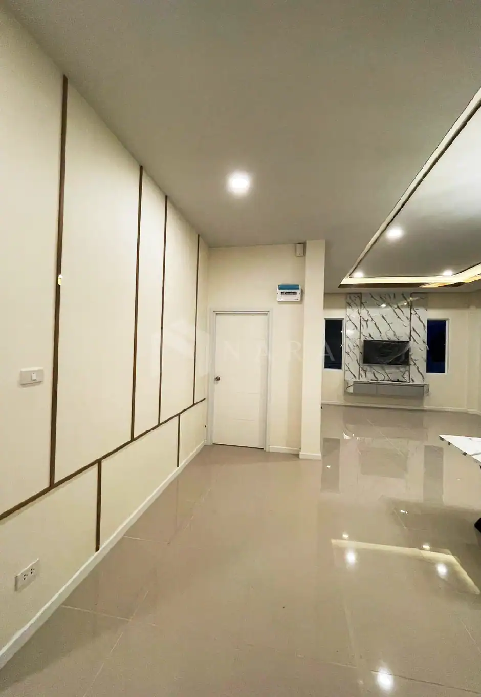 Elegant gold-colored stainless steel trim accents enhance the wall design of a modern, minimalist living space, adding sophistication and a luxurious touch to the interior decor.