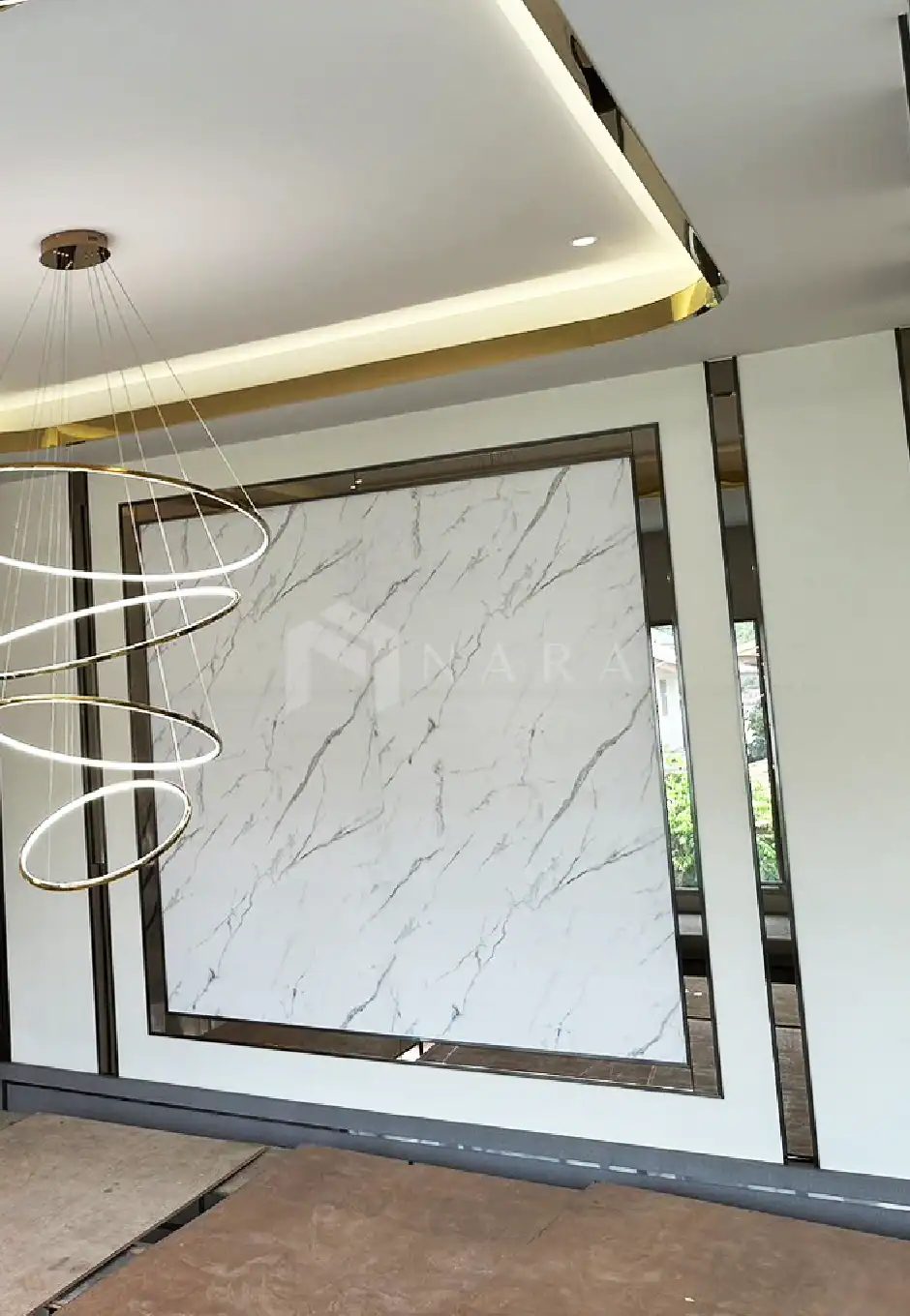 Shiny gold stainless steel trim and wall accents complement modern interior design with marble wall panel and elegant lighting.