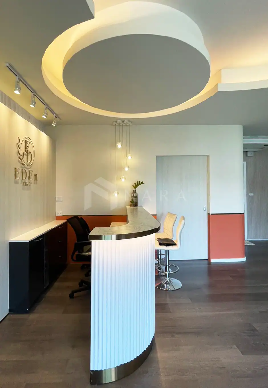 Shiny gold-colored stainless steel trim and decorative accents in a modern clinic reception area with stylish lighting and minimalistic decor, creating a luxurious and elegant ambiance.