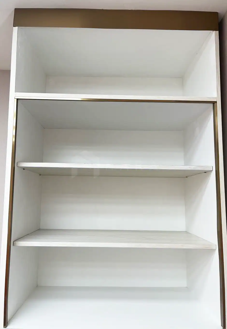 Shiny gold-colored stainless steel decorative corner trim for kitchen shelves or furniture accents, adding a luxurious touch to interior designs.
