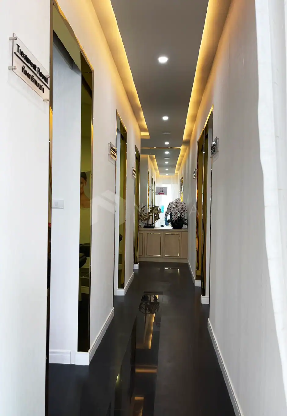 Glossy gold stainless steel corner trims used as decorative accents in a modern hallway interior design.