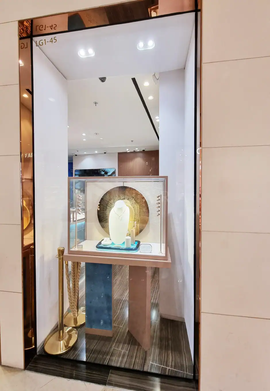 Shiny gold stainless steel display frame with jewelry showcase and decorative background, highlighting premium gold-colored stainless steel finishes for luxury interior or retail decor.