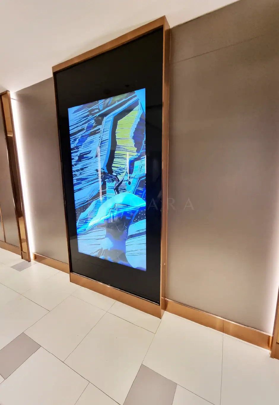 Shiny gold stainless steel corner trim framing a large digital screen on a modern wall interior. High-quality decorative stainless steel accents add elegance and sophistication to contemporary design spaces.