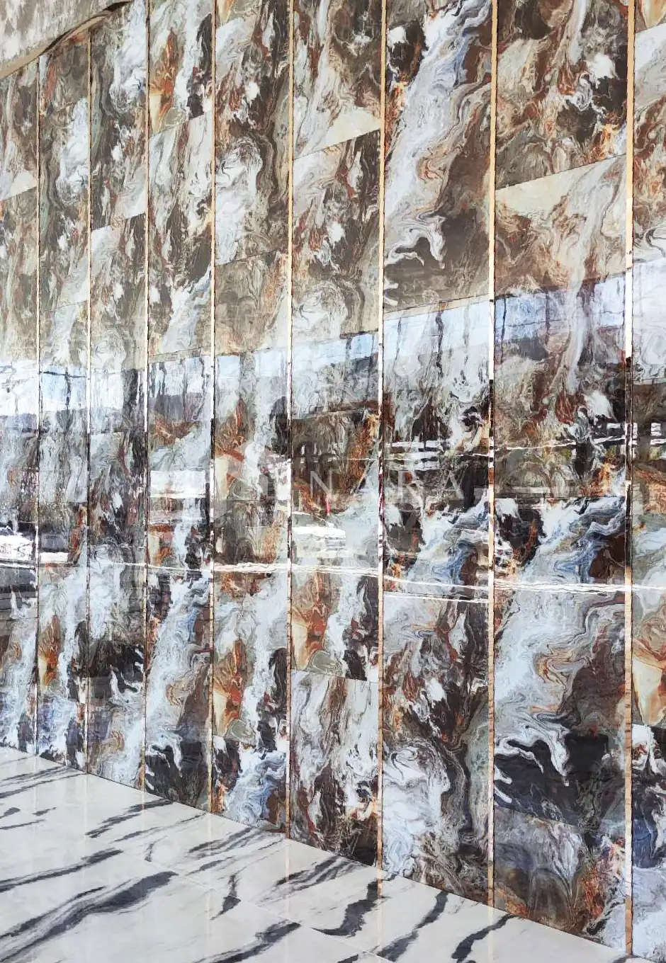 Vibrant brown, white, and black marble wall tiles with swirling patterns, paired with a matching marble floor featuring bold black veining, creating a luxurious and elegant interior design.