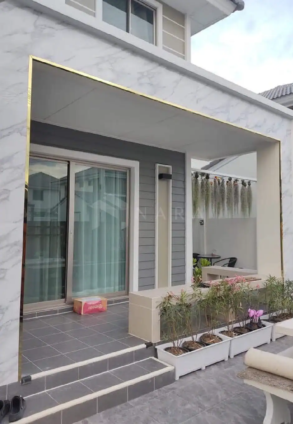 Elegant gold-colored stainless steel trim used for exterior decoration on a modern residential building.