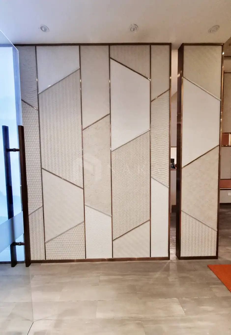 1. Gold stainless steel accent wall with geometric textured panels and sleek metal borders, adding modern elegance to interior spaces.