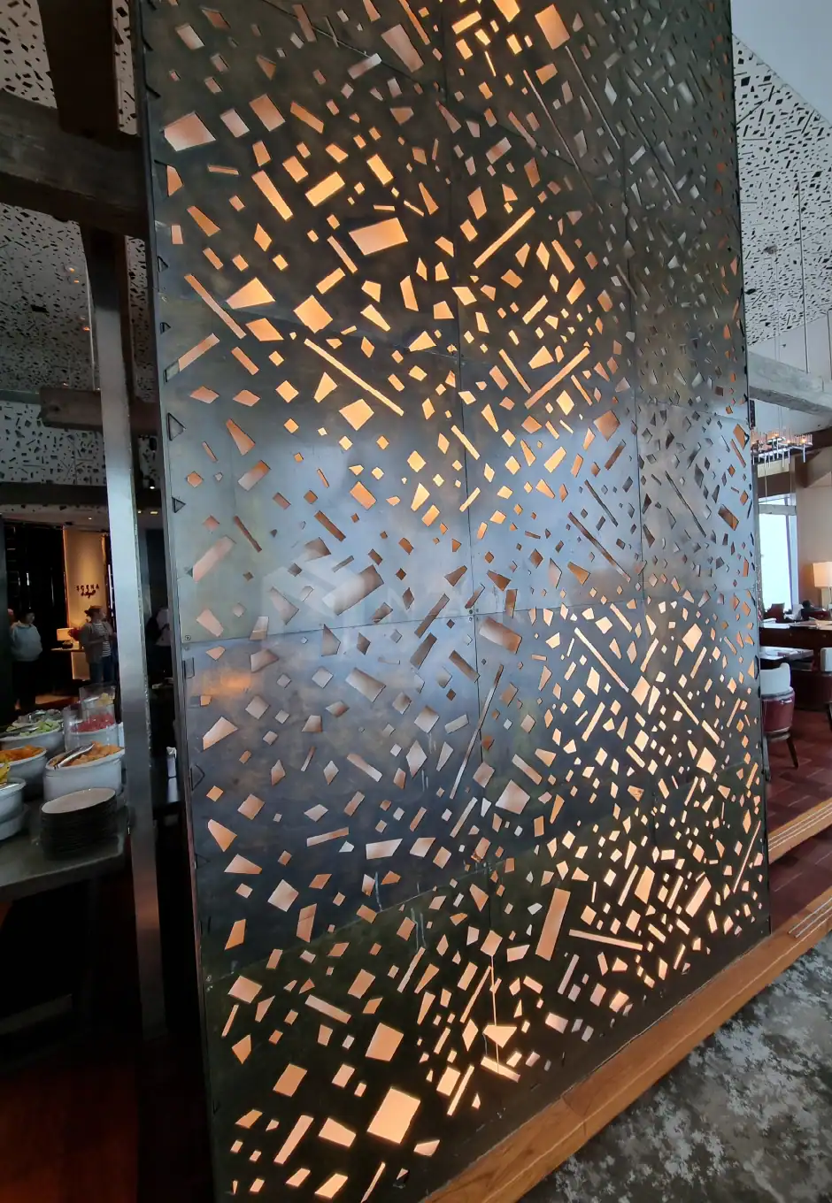 Sleek gold-colored stainless steel decorative wall panel with geometric cut-out patterns, perfect for modern interior design and luxury restaurant or hotel décor.