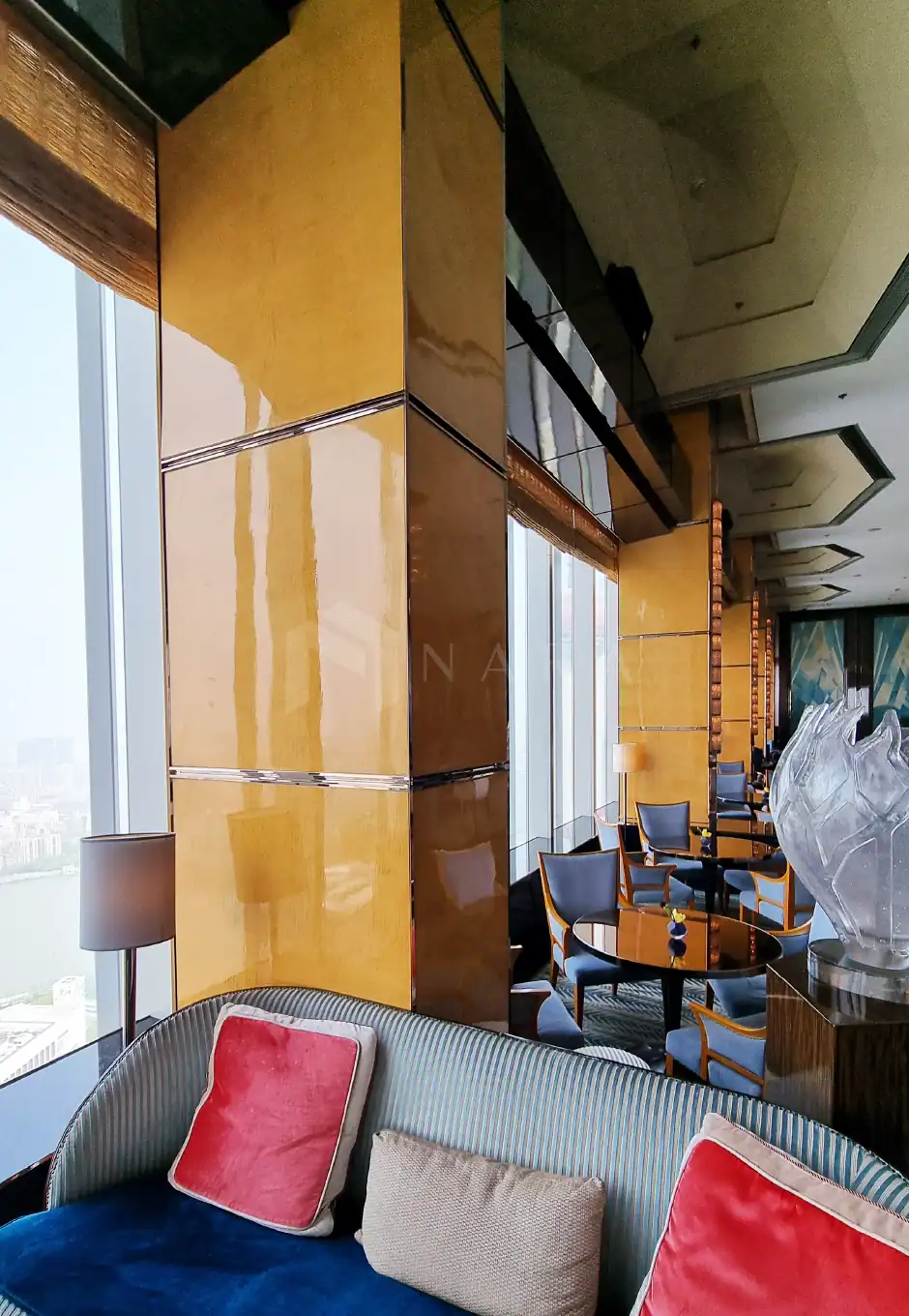 Shiny gold stainless steel decorative trims in an upscale modern hotel lounge with large windows, plush seating, and elegant interior design accents enhancing luxury ambiance.